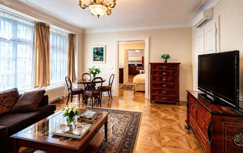 Elegant living space with high ceilings, parquet floors, and natural light.