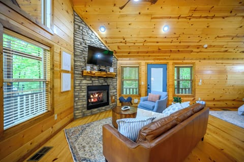Gather around the crackling stone fireplace beneath soaring wood ceilings, where plush seating and abundant natural light create your perfect mountain retreat for cozy evenings together.