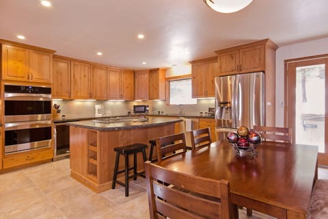 The kitchen is equipped with a smaller dining table, providing an inviting space for casual meals or a comfortable spot to enjoy a meal with loved ones