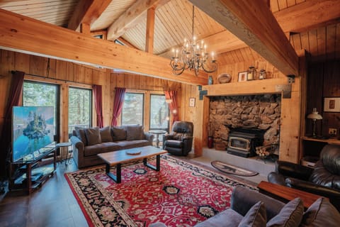 This beautifully appointed living room features a large flat-screen TV and a wood-burning fireplace, offering both modern amenities and rustic charm in a spacious, comfortable setting