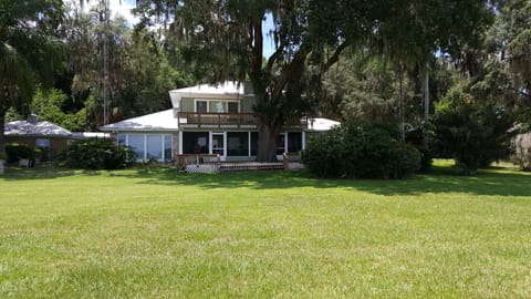 view of house from the lake  sun rm & guest rm on left. screened porch & balcony