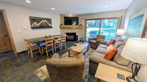 Living room with sofa bed, gas fireplace, dining table, and patio w/ gas BBQ