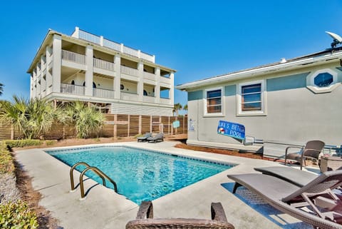 Poolside view of the home w/ seating and space to unwind outdoors.