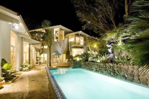 Heated swimming pool and back of house at night.