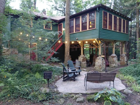 Creekside patio with firepit, grill, and string lights
