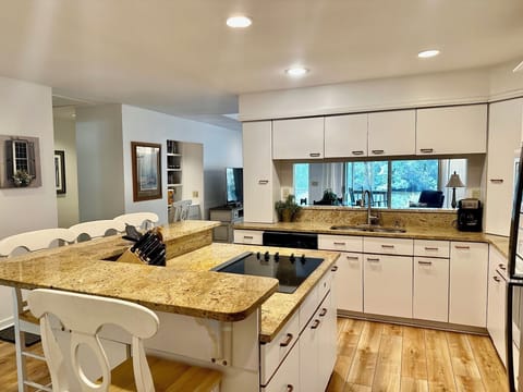 Bright, large kitchen with granite countertops, large island and barstools. 