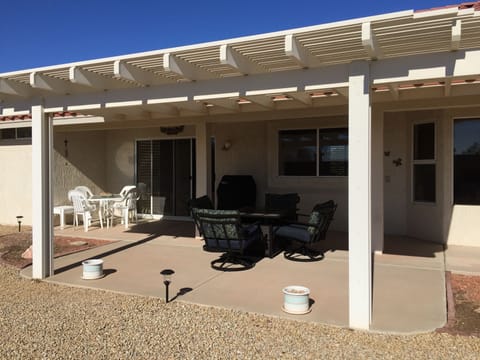 backyard patio with fire pit table and chairs and Weber bbq