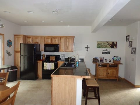 Kitchen features newer appliances, deep sink, and 3 barstools.
