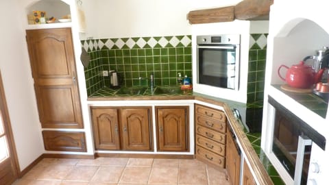 Provencal kitchen, ceramic hob and eye level oven and fridge.