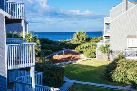 Step outside and take it all in — your multi-story Gulf-view townhome with layered decks, lush landscaping, and the water already waiting.