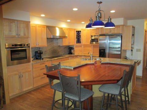 gourmet kitchen with custom table and chairs.  Also full dining table adjacent