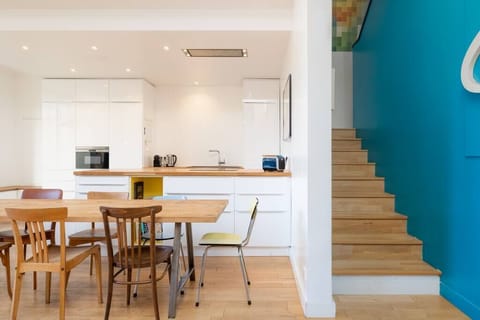 Un grand escalier mène de la pièce de vie au 1er étage où se trouvent une partie des chambres.