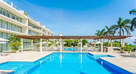 Dive into paradise! Your sunny escape awaits by the sparkling pool and palms.