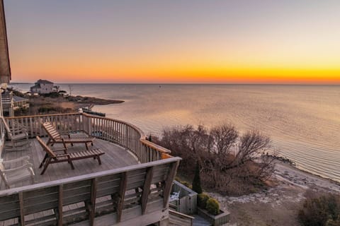 Golden sunset paints the sky as your private deck overlooks endless ocean views, perfect for morning coffee or evening relaxation.
