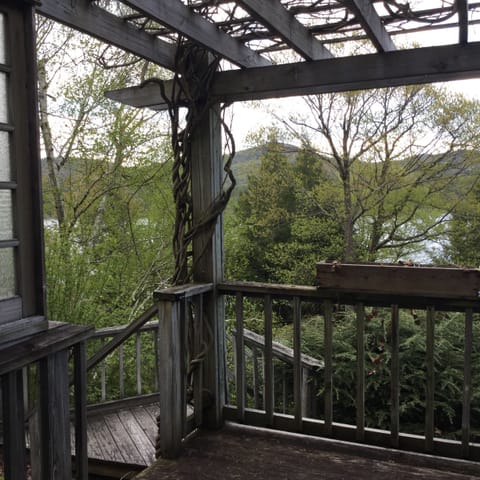 Deck on front of house with steps leading down to the lakefront deck and dock.
