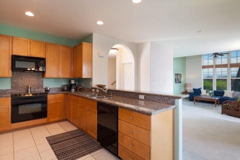 Full kitchen with breakfast bar, granite countertops, and modern appliances