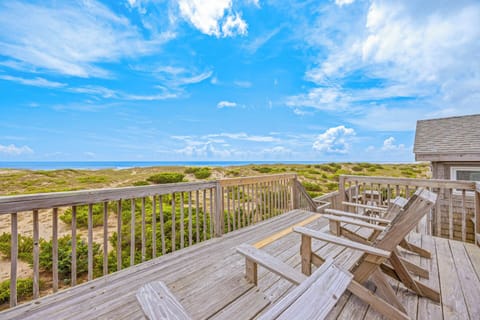 This beachfront property offers a private deck with sweeping ocean views, bordered by natural coastal dunes. The property provides direct beach access in a serene setting.