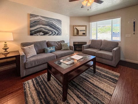 Cozy living room with plush seating, warm fireplace, and natural light for perfect relaxation.