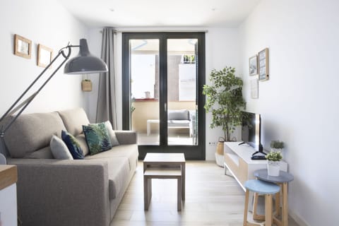 Here you can see the terrace and the living room of the holiday apartment in Sitges, with a sofa bed, television and air conditioning.