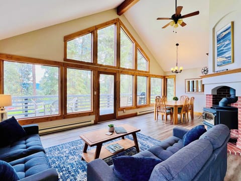 Living room with access to the deck, dining area and kitchen with vaulted ceilings