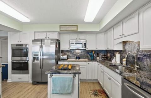 The kitchen is features a large island, gorgeous granite countertops, and is equipped with everything you need, including a double oven!