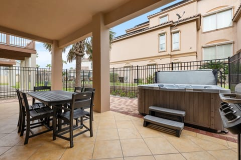 Private patio with outdoor dining, propane grill, and hot tub