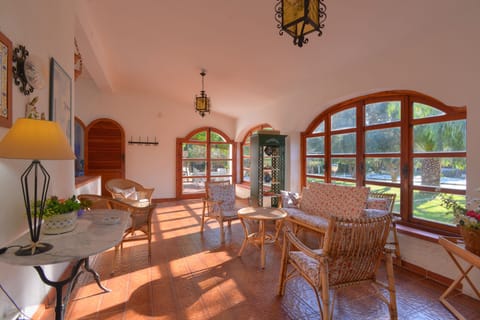 Living area with seating and garden and pool views.