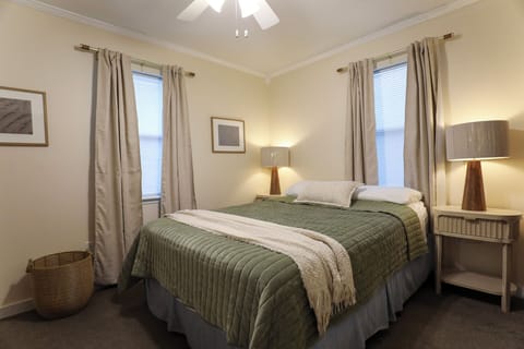 Unwind your peaceful primary bedroom suite with crisp linens, calming coastal decor, and private attached bath.