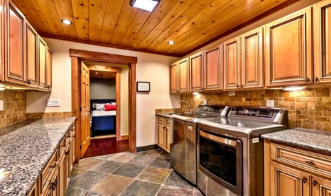 Luxurious and spacious laundry room w/over-sized washer + dryer & granite tops