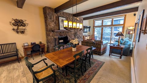 Living room with sofa bed, wood fireplace, dining table, and balcony w/ gas BBQ