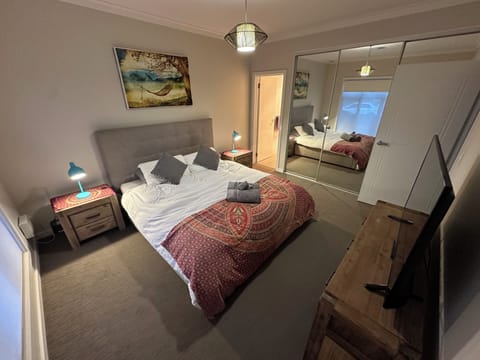 Master bedroom with king size bed, TV, built in wardrobe and ensuite