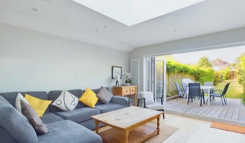 Light and spacious open-plan living area with comfortable seating, Smart Freeview TV and bi-fold doors opening onto the private garden.
