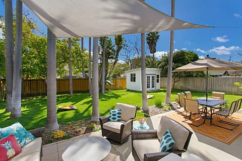 Fully fenced large backyard with tall palm trees rustling in the ocean breeze