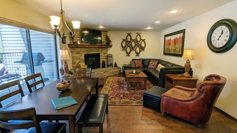 Living room with sofa bed, gas fireplace, dining table, and patio with gas BBQ