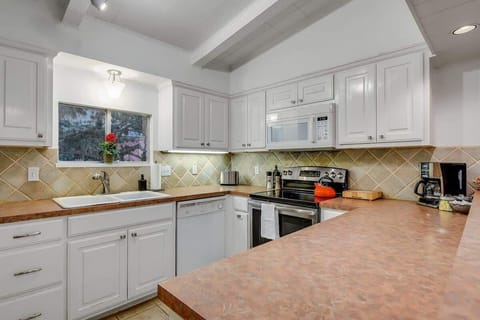 Kitchen area (complete with a sink, countertop, fridge, microwave, stove, utensils, coffee maker)