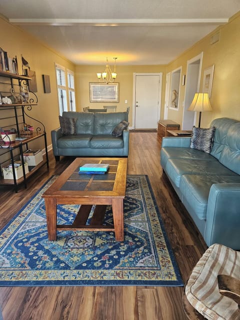 Living room with a smart TV, leather couches, and private balcony.