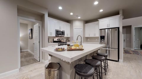 Photo of whole room stocked with all the comforts of home. Featuring top of line appliances and cooking utensils.