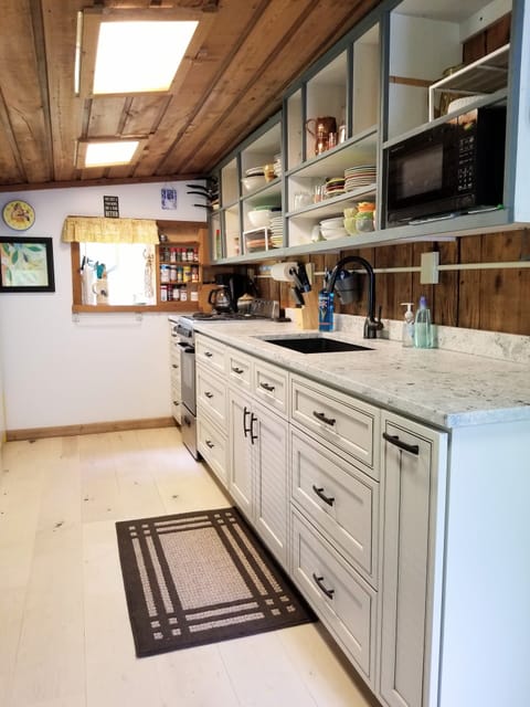 Newly installed kitchen cabinets, sink, and granite counter tops.