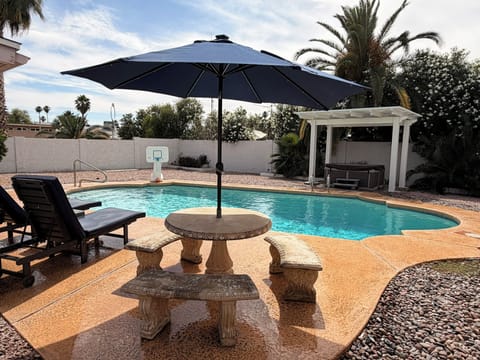 Large outdoor space with patio loungers, chairs, dining area, and hot tub.