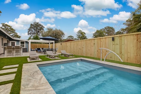 Private heated pool with outdoor grill/kitchen, dining table and shaded seating