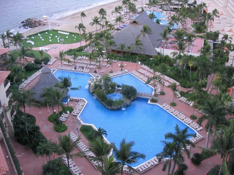 View of the pool area with a swim up bar and hot tube.