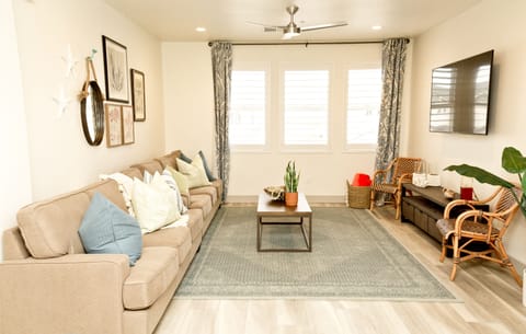 Large living area with sectional seating, smart TV, and plenty of natural light.