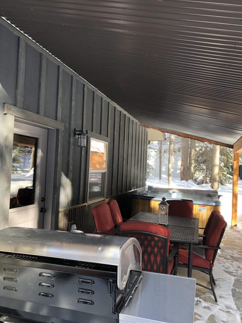 Covered Back Patio. Six-Person Hot Tub, Outdoor Table with Cushioned Chairs.