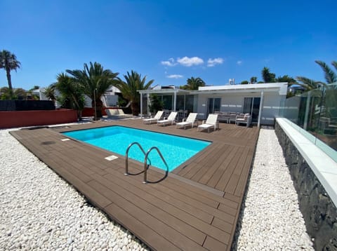 Modern style: private pool surrounded by elegant wooden decking and solarium area.