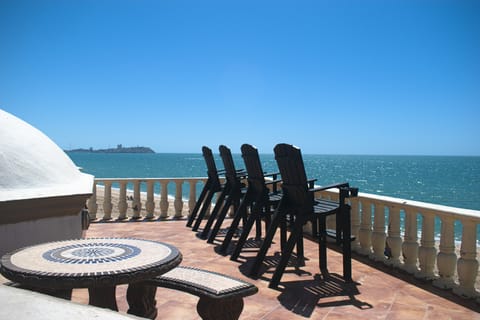 Roof top view with comfortable chairs along with round table and benches positioned up top as well.   Beautiful and truly a favorite place to hang out and see all of Sandy Beach/pool area.