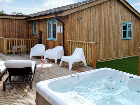 Extended decking areas with loungers and hot tub | Eagle Owl Lodge, St Columb Major, near Padstow