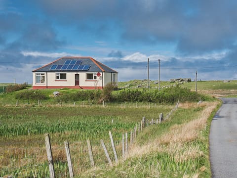 Sitting on a raised area close to the Loch Roag shore | Padraig’s Cottage, Howbeg (Tobha Beag), Isle of South Uist