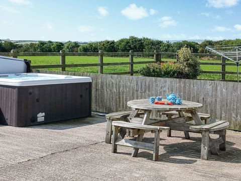 Outside area with hot tub and sitting are. Also enclosed garden | Rhosydd Cottage, Llandyfrydog, near Amlwch