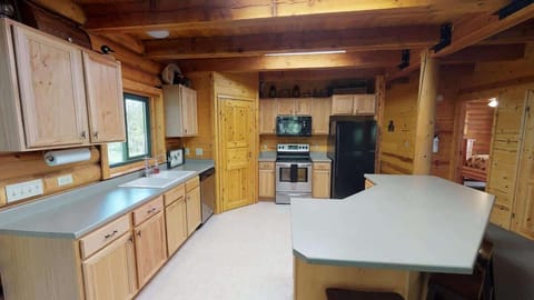 Large kitchen with appliances, cookware, dishes, and basic cooking essentials.