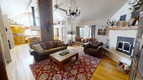 Unwind in your spacious living area with vaulted ceilings, plush leather seating, and a cozy wood-burning fireplace perfect for relaxing after a day of mountain adventures.